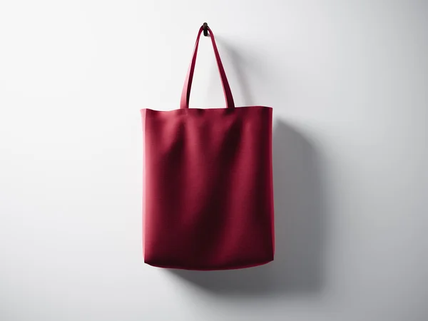 Bolso textil de algodón rojo fotográfico colgado en el centro. Fondo de pared blanco vacío. Textura muy detallada, espacio para la publicidad. Horizontal. 3d renderizar — Foto de Stock