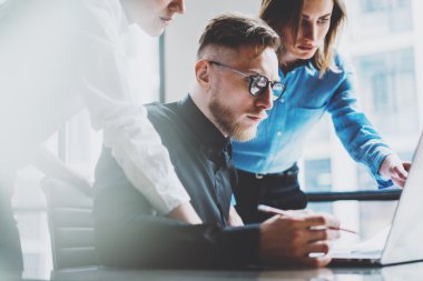 Fotoğraf genç iş arkadaşları ekibi modern loft yeni başlangıç projesi ile çalışıyor. Kalem el ele tutuş, dizüstü bilgisayar, planları analiz et. Yatay, film efekti, bulanık arka plan