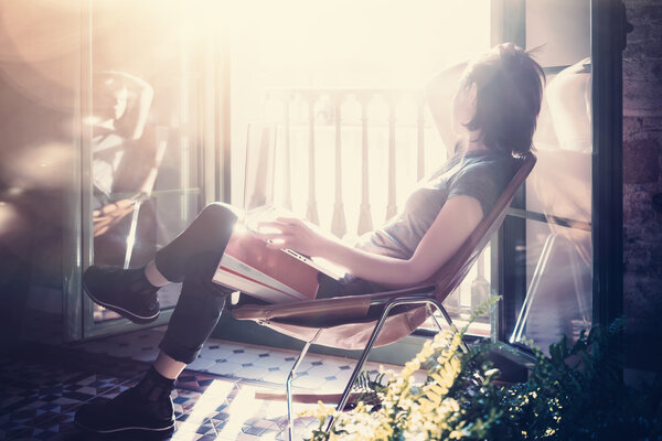 Photo young girl sitting leather armchair in modern building and use laptop wireless internet. Studying at the University, working, preparing exams. Using book, notebook. Sunny day. Horizontal