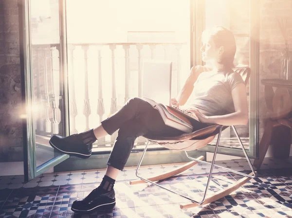 Foto jong meisje zitten lederen fauteuil in modern gebouw en gebruik laptop draadloos internet. Studeren aan de Universiteit, werken, examens voorbereiden. Met behulp van boek, hedendaagse computer. Horizontale — Stockfoto