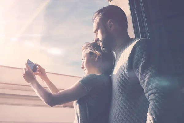 Viagem de verão de casal jovem. Foto mulher e barbudo homem fazendo selfie telefone celular. Usando smartphone contemporâneo, sorrindo. Horizontal, efeito filme . — Fotografia de Stock