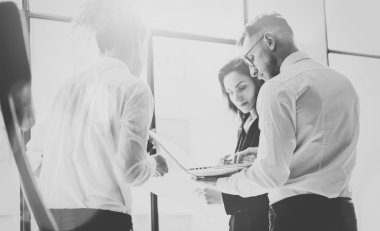 Business team work process. Photo professional crew working with new startup project. Project managers meeting. Analyze business plans laptop. Blurred background, film effect, black white. Horizontal