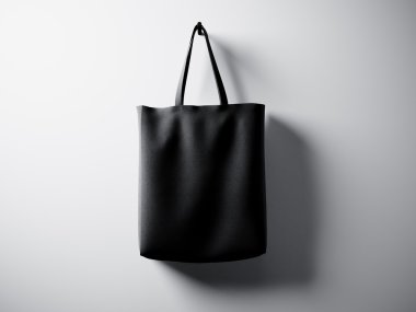 Fotoğraf siyah pamuk tekstil çanta merkezinde asılı. Boş beyaz duvar arka planı. Son derece ayrıntılı doku, iş mesajı için alan. Yatay. 3d render