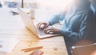 Hesap yöneticisi çalışma resmi. Fotoğraf genç iş kadını ofiste yeni başlangıç projesi ile çalışır. Belgeyi, planları analiz et. Ahşap masada laptop, fincan kahve, belgeler. Yatay, bulanık. Film efekti