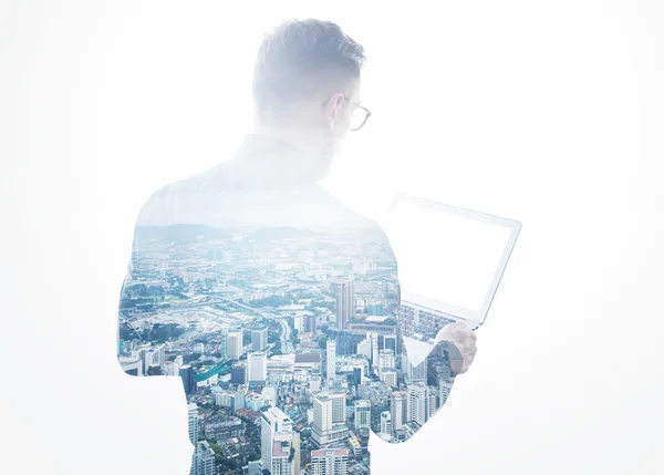 Double exposure young bearded businessman wearing black shirt holding contemporary notebook hands.Isolated white,modern city background.Blank screen ready for your business message.Horizontal mockup — Stock Photo, Image