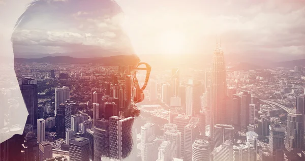 Foto de primer plano del banquero barbudo con estilo que usa gafas y busca la ciudad. Doble exposición, vista panorámica de fondo megalópolis contemporánea. Espacio para su mensaje de negocios. Efecto amplio, al atardecer —  Fotos de Stock