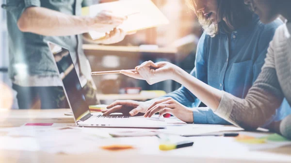 Takım beyin fırtınası. Fotoğraf genç yaratıcı yöneticiler mürettebat modern ofiste yeni başlangıç projesi ile çalışıyor. Ahşap masa üzerinde çağdaş defter. Yatay, film efekti