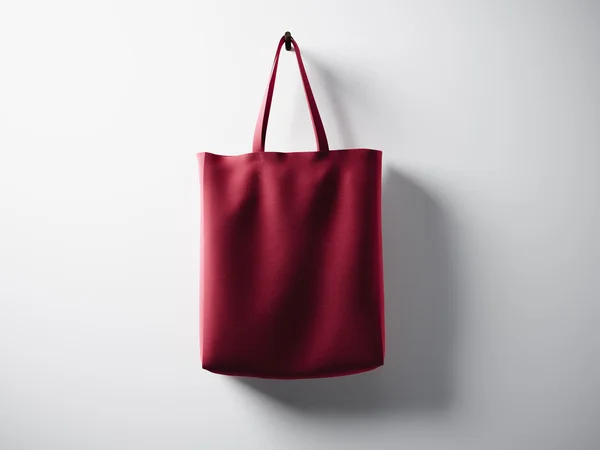 Foto rote Baumwolltextiltasche, die in der Mitte hängt. leere weiße Wand Hintergrund. hochdetaillierte Textur, Platz für Werbung. horizontal. 3D-Darstellung — Stockfoto