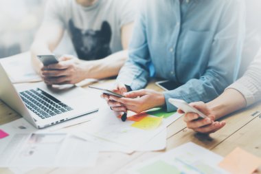 Fotoğraf coworking takım toplantısı. Stüdyoda yeni başlangıç projesi ile çalışan genç işadamı ekibi. Ahşap masa üzerinde modern defter. Çağdaş akıllı telefonları kullanarak, mesaj layıyorum. Yatay, film efekti