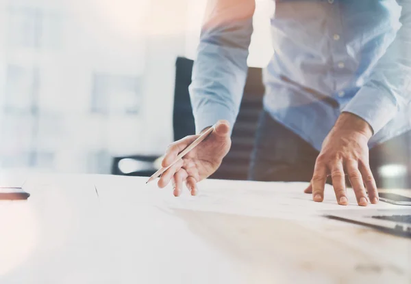 Inicio del proceso de trabajo. Empresario trabajando en la mesa de madera con un nuevo proyecto financiero. Cuaderno moderno en la mesa. Lápiz de la mano. Una maqueta horizontal. Bengalas, efecto de película — Foto de Stock