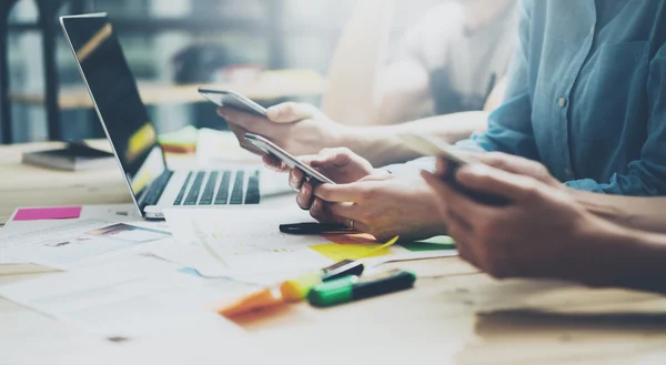 Team coworking process. Photo young business crew working with new startup project.Notebook on wood table. Using modern smartphones, typing message, analyze plans. Blurred background, film effect.Wide — Stock Photo, Image