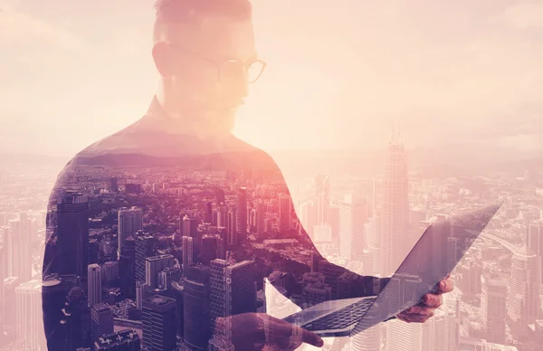 Double exposure businessman wearing black shirt and glasses.Banker holding contemporary notebook hands.Using work online banking system. Modern city sunset background. Horizontal mockup — Stock Photo, Image