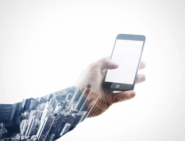 Doble exposición foto hombre de negocios sosteniendo la mano del teléfono inteligente moderno, tocando la pantalla en blanco.Blanco aislado, fondo de la ciudad contemporánea. Listo para su mensaje de negocios. Una maqueta horizontal. Efecto película —  Fotos de Stock