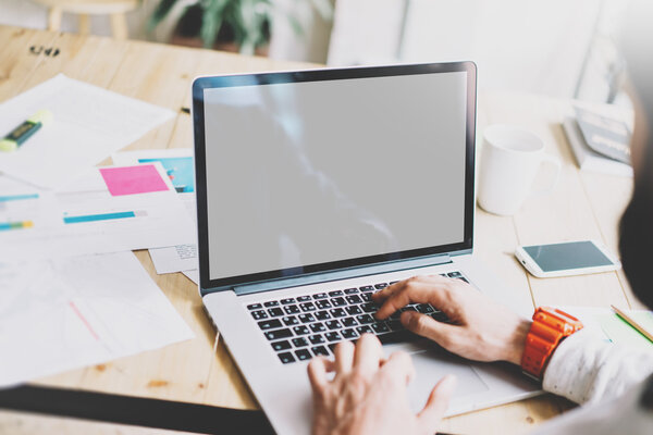 Closeup photo graphic designer working with new project modern loft.Using contemprary laptop on wood table.Creative process.Mockup notebook reflections screen.Blurred background,film effect,horizontal