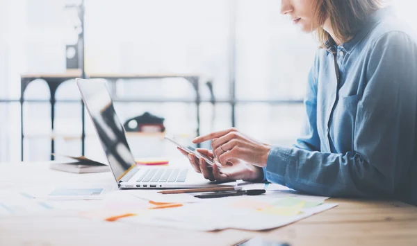 Working process photo. Account manager working wood table with new business project. Typing contemporary smartphone screen. Horizontal. Film effect. Blurred background — Stock Fotó