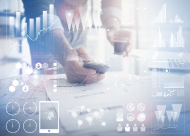 İş konsepti fotoğraf. İşadamı çalışan yeni başlangıç projesi modern ofis. Çağdaş akıllı telefon ellerini tutmak. Dünya çapında bağlantı teknolojisi, borsalar grafik arayüzü. Yatay