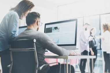 Coworking işlemi, tasarımcılar ekibi modern ofis çalışıyor. Fotoğraf genç yaratıcı Yöneticisi gösteren yeni başlangıç fikir monitör. Ahşap masa masaüstü bilgisayarlarda. Arka plan bulanık, film etkisi. Yatay