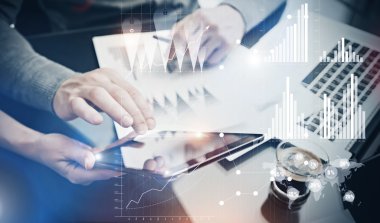 Fotoğraf takım çalışması süreci. Risk departmanı yöneticileri ofiste yeni küresel proje çalışıyor. Elektronik cihazları kullanmak. Grafik simgeleri, dünya çapında borsaarayüzü. Yatay