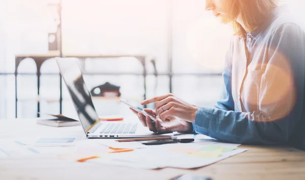 Working process photo. Account manager working wood table with new business project. Typing contemporary smartphone screen. Horizontal. Film and flares effects. Blurred background — Stockfoto