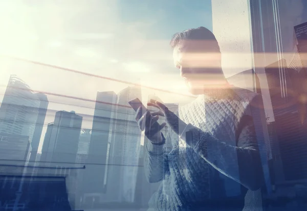 Double exposure photo man touching screen smartphone.Picture bearded trader manager in modern loft.Contemporary city skyscrapers background. Film and bokeh effect.Horizontal