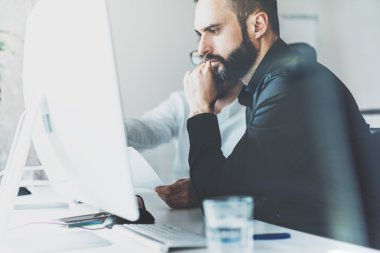 Birlikte çalışma süreci fotoğraf. Yaratıcı yöneticiler ekibi yeni bir proje üzerinde çalışır. Genç iş ekibi başlangıç modern ofis ile çalışıyor. Masaüstü bilgisayar masada, düşünme fikri. Bulanık, film efekti. Yatay