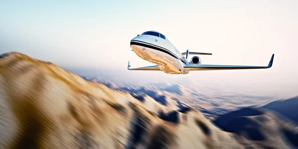 Obraz białego nowoczesnego i luksusowego ogólnego projektu prywatnego odrzutowca latającego w błękitnym niebie o wschodzie słońca. Niezamieszkałe pustynne tło górskie. Zdjęcie podróży służbowych. Poziomo, ruch niewyraźne efekt. renderowanie 3D — Zdjęcie stockowe
