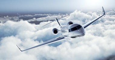Realistic image of White Luxury generic design private jet flying over the earth. Empty blue sky with white clouds at background. Business Travel Concept. Horizontal. 3d rendering