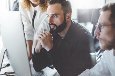 Modern ofiste iş arkadaşları takım fotoğrafı. Proje yöneticileri yeni bir fikir çalışır. Genç iş ekibi tartışma başlangıç. Masaüstü bilgisayar masada, sunuyu gösteriyor. Bulanık, film efekti. Yatay