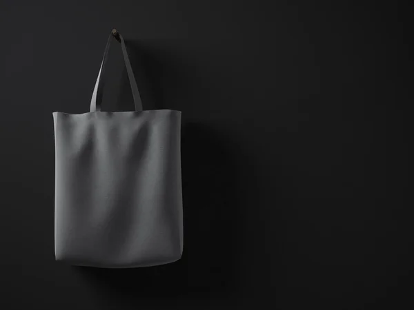 Photo dark gray cotton textile material bag hanging in left side. Empty concrete black painted wall background. Highly detailed texture, space for your business message. Horizontal mockup.3D rendering — Stock Photo, Image