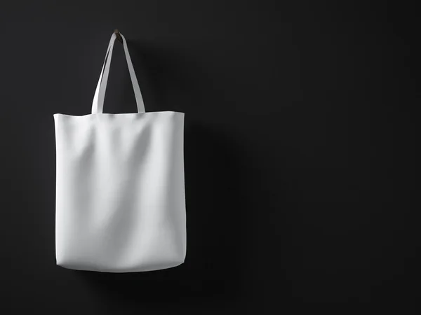 Photo white color cotton textile material bag hanging left side. Empty concrete black painted wall background. Highly detailed texture, space for your business message.Horizontal mockup.3D rendering — Stock Photo, Image