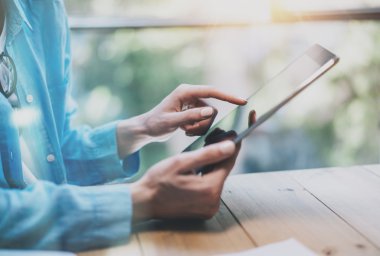 Work process modern Studio.Hipster working wood table with new freelance business startup. Using Digital Tablet,Touching Screen. Horizontal.Film effect, flares. Blurred background