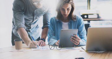 Modern loft'ta birlikte çalışan ekip beyin fırtınası süreci. Proje yöneticisi düşünüyor, gözlük kadın eli tutuyor. Genç iş ekibi başlangıç stüdyosu ile çalışıyor. Dizüstü masa, tablet kullanarak. Bulanık, film effec