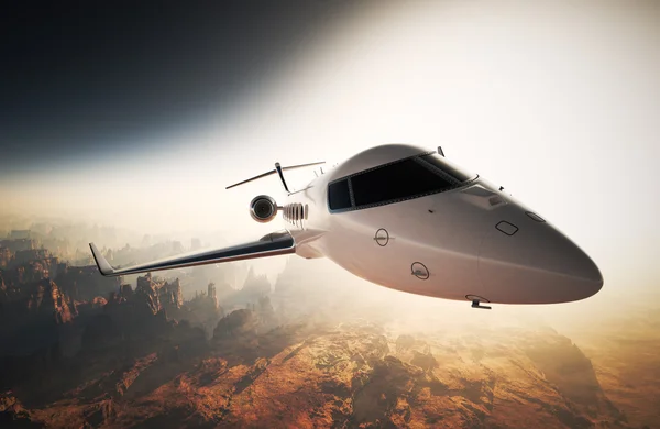 Foto Bianco lucido Design generico Private Jet Volare in cielo sotto la superficie della terra.Grand Canyon sfondo Tramonto. Foto di viaggio d'affari.Orizzontale, ad angolo retto. Rendering 3D . — Foto Stock