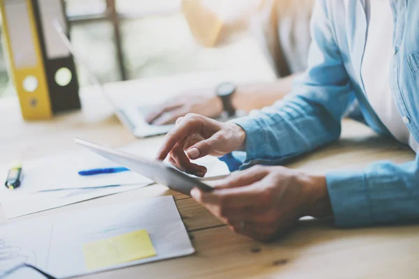 Work Process in Modern Studio. Young Account Manager Working at Wood Table with New Business Project.Touching Screen Digital Tablet.Man Wearing using Laptop.Horizontal. Film efect. Blurred background. — Stock Photo, Image