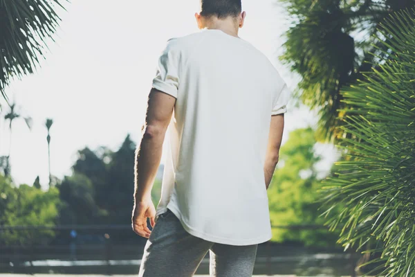 Foto Homem Muscular Barbudo Vestindo camiseta branca em branco no verão. Green City Garden Background, desfocado. Vista traseira. Mockup horizontal — Fotografia de Stock