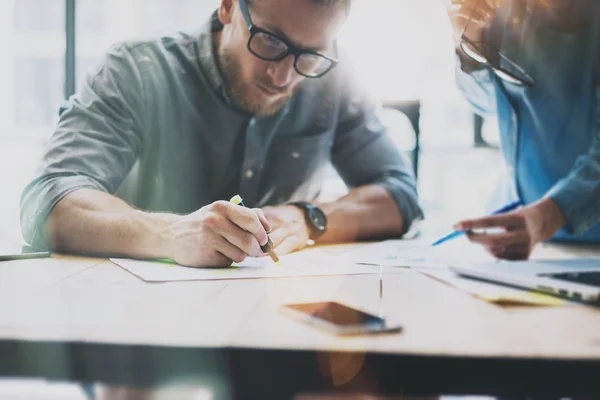 Coworking-vergadering. Picture Young Creative crew werkt met een nieuw Startup project. Bureaublad op houten tafel. Ideeën presentatie, marketingplannen analyseren. Onscherpe achtergrond, lichteffecten, filmeffect. — Stockfoto