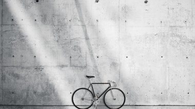 Horizontal Photo Blank Grungy Smooth Bare Concrete Wall in Modern Open Space Studio with Classic bicycle. Soft Sunrays Reflecting on Surface. Empty Abstract background.