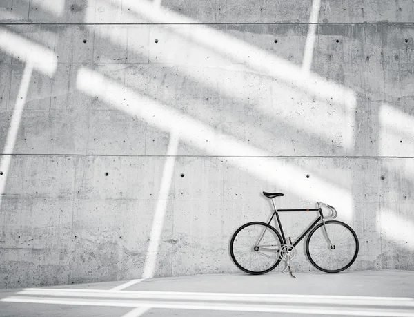 水平照片空白粗光光滑裸裸混凝土墙在现代阁楼工作室与经典自行车。柔软的太阳光线在表面上反射。空抽象背景. — 图库照片