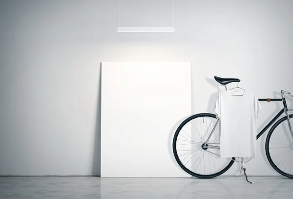 Foto-Interieur modernes Studio-Loft mit Betonwand und klassischem Fahrrad.Leere weiße Leinwand auf dem Boden, Scheinwerfer oben. leeres T-Shirt hängendes Fahrrad. horizontale Attrappe. — Stockfoto