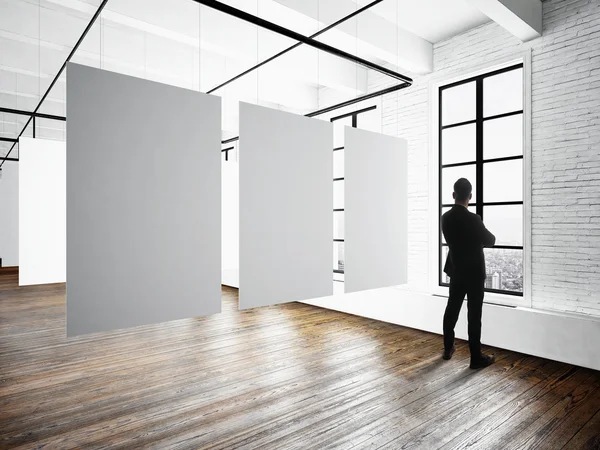Üzletember Modern Múzeum expo loft belső. Nyitott tér studio. Üres fehér vászon függő. Fa padló, fal tégla, panoráma ablakokkal. Üres keretek készen áll a üzleti információt. Vízszintes makett. — Stock Fotó