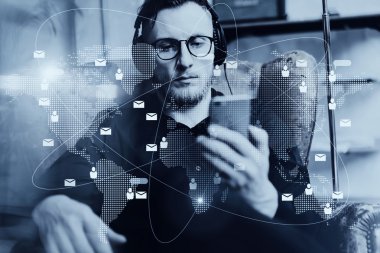 Portre yakışıklı adam kulaklık müzik dinleme, video cep telefonu modern çatı stüdyo izlerken sakallı. Adam holding smartphone ve rahatlatıcı. Bağlantıları dünya geniş arabirimleri. Yatay, siyah beyaz.