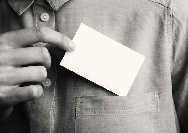 Hombre mostrando una tarjeta de visita vacía. Un hombre de negocios adulto saca una tarjeta en blanco del bolsillo de su camisa. Listo para su información privada. Blanco y negro. Maqueta horizontal. . — Foto de Stock