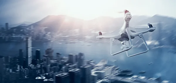 Photo White Matte Generic Design Remote Control Air Drone with action camera Flying Sky under City. Modern Megapolis Background. Wide, side angle view. Motion blur Effect. 3D rendering. — Stock Photo, Image