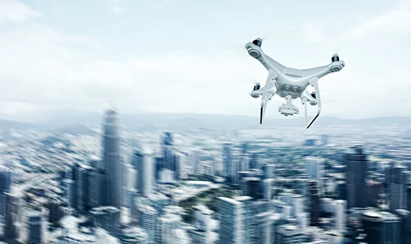 Foto weiß matt generisches Design ferngesteuerte Luft-Drohne mit Action-Kamera fliegen Himmel unter der Stadt. moderner Megapolis-Hintergrund. horizontale, rückseitige Ansicht. Bewegungsunschärfeeffekt. 3D-Darstellung. — Stockfoto