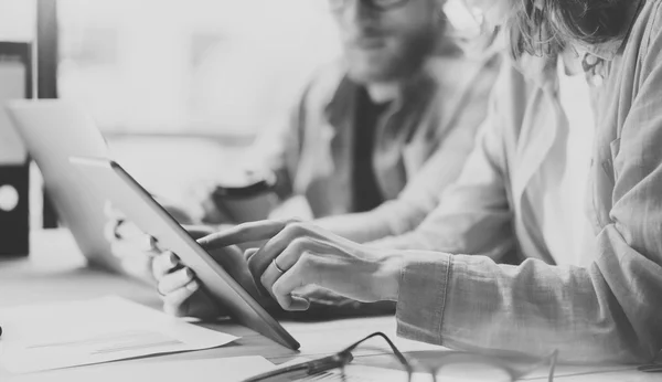 Los compañeros de trabajo trabajan estudio de diseño moderno.Equipo de gerentes de producción que trabaja nuevo proyecto.Joven equipo de negocios discusión startup.Laptop mesa de madera del ordenador portátil, utilizando tablet.Blurred digital, blanco negro.Horizontal . —  Fotos de Stock