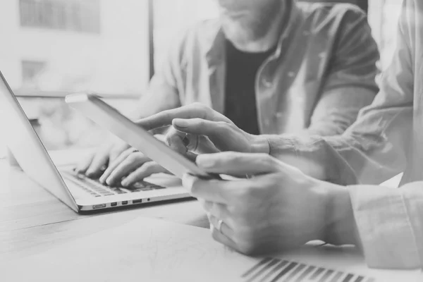 Arbeitsprozess im Modern Design Studio. Kontoverwalter arbeiten am Holztisch mit neuem Geschäftsprojekt. Touchscreen Digital Tablet.Man mit Laptop.Horizontal. Schwarz-Weiß. Unklarer Hintergrund. — Stockfoto