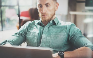 Sakallı İşadamı çalışma Laptop modern İç Tasarım Loft Studio.Man oturan Vintage sandalye. Çağdaş Not Defteri, bulanık arka plan kullanın. Yaratıcı Yeni iş Başlangıç Idea.Horizontal, film etkisi.