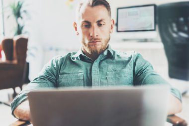 Sakallı İşadamı çalışma Laptop modern İç Tasarım Loft Studio.Man rahatlatıcı Vintage sandalye. Çağdaş Not Defteri, bulanık arka plan kullanın. Yaratıcı Süreç Yeni Başlangıç Fikirler.Wide, film effec