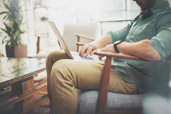 Bearded Businessman working Laptop modern Interior Design Loft Studio.Man sitting Vintage chair.Use contemporary Notebook, blurred background.Creative Process New Startup Idea.Horizontal, film effect . — стоковое фото