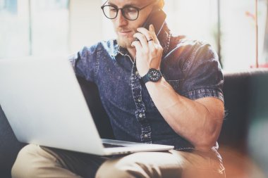 Kas Sakallı Hipster çalışma Laptop modern İç Tasarım Loft Office.Man Oturan Vintage Kanepe.Kullanarak çağdaş Smartphone Hand.Blurred Background.Creative Business Startup Process Idea.Film.